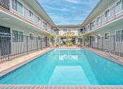 Thumbnail 30 of 35 - A swimming pool in a residential area surrounded by buildings.