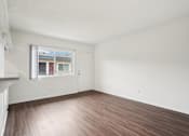 Thumbnail 25 of 35 - A room with a window and wooden flooring.