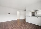 Thumbnail 15 of 35 - A room with white walls and wooden flooring with a white cabinet and a white door.