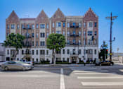 Thumbnail 2 of 40 - A street view of a large white building with a sign that reads