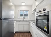 Thumbnail 9 of 35 - A modern kitchen with stainless steel appliances and white cabinetry.
