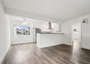 Thumbnail 4 of 35 - A spacious room with wooden flooring and white walls.
