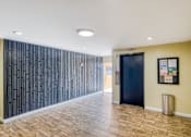 Thumbnail 30 of 32 - A hallway with a black door and a wall with a pattern of black panels.