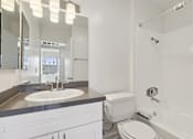 Thumbnail 24 of 32 - A white bathroom with a sink, toilet, and bathtub.