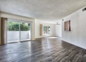 Thumbnail 7 of 8 - an empty living room with wood flooring and a sliding glass door