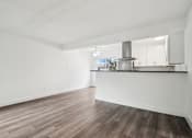 Thumbnail 6 of 35 - A spacious room with wooden flooring and white walls.