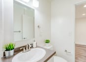 Thumbnail 17 of 20 - A bathroom with a white sink and a mirror above it.