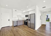 Thumbnail 6 of 23 - A modern kitchen with wooden floors and stainless steel appliances.