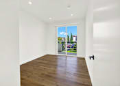 Thumbnail 19 of 23 - A room with a wooden floor and a sliding glass door.