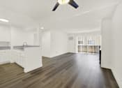 Thumbnail 16 of 23 - A spacious kitchen with white cabinets and a wooden floor.