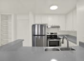 Thumbnail 14 of 23 - A modern kitchen with a stainless steel refrigerator and a sink.