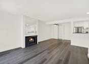 Thumbnail 13 of 23 - A modern living room with a fireplace and wood flooring.