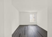 Thumbnail 11 of 23 - A room with wooden floors and white walls.