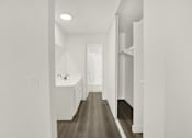 Thumbnail 10 of 23 - A long, narrow hallway with a sink and wooden floors.