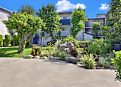 Thumbnail 5 of 23 - A residential area with a well-maintained garden and apartment buildings.