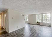 Thumbnail 10 of 18 - A large empty room with wooden floors and white walls.