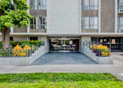 Thumbnail 4 of 15 - the entrance to an apartment building with a yard and a tree in front of it