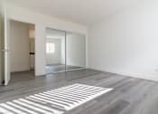 Thumbnail 14 of 16 - A room with a sliding glass door and a wooden floor.