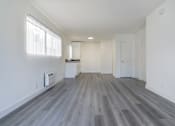 Thumbnail 11 of 16 - A room with a wooden floor and white walls.