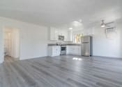 Thumbnail 8 of 16 - A spacious kitchen with white cabinets and a grey floor.