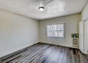 Thumbnail 10 of 15 - A room with a window and a wooden floor.