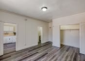 Thumbnail 9 of 15 - A room with a wooden floor and white walls.