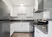 Thumbnail 10 of 35 - A modern kitchen with white cabinets and stainless steel appliances.