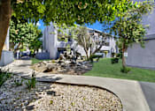 Thumbnail 4 of 23 - A residential area with a gravel path and trees.