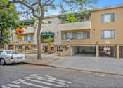 Thumbnail 2 of 19 - A street view of a building with a car parked in front.