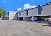 Thumbnail 1 of 23 - A parking lot with a blue car parked in front of a building.