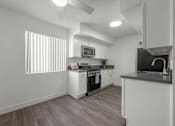 Thumbnail 17 of 64 - A modern kitchen with white cabinets and a wooden floor at Sunset Square, West Covina, 91790