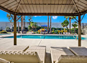 Thumbnail 51 of 55 - A pool area with sun loungers and a canopy.
