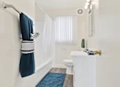 Thumbnail 30 of 55 - A white bathroom with a towel hanging on the wall.
