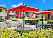 Thumbnail 6 of 64 - a patio with tables and umbrellas in front of an apartment building at Sunset Square Apartments, West Covina, California, 91790