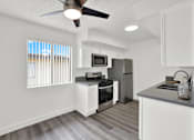 Thumbnail 15 of 64 - an open kitchen with a window and a ceiling fan at Sunset Square Apartments, West Covina, California, 91790