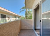 Thumbnail 10 of 10 - A balcony with a glass door leading to a house.