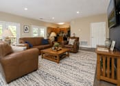 Thumbnail 10 of 21 - A living room with brown leather furniture and a blue carpet.