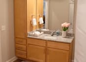 Thumbnail 16 of 21 - A bathroom with a wooden vanity and a large mirror.