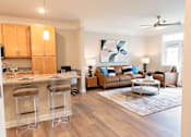 Thumbnail 15 of 21 - A modern kitchen with wooden floors and a bar area.