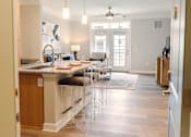 Thumbnail 14 of 21 - A kitchen with a marble countertop and bar stools.