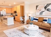 Thumbnail 13 of 21 - A modern kitchen with a bar stool and a white coffee table.
