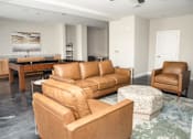 Thumbnail 8 of 21 - A living room with brown leather furniture and a painting on the wall.