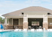 Thumbnail 7 of 21 - A pool house with a swimming pool in front.