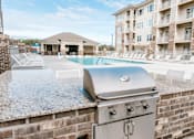 Thumbnail 5 of 21 - A BBQ grill is on a patio next to a swimming pool.