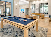 Thumbnail 6 of 32 - A pool table with a blue cloth and white balls is in the center of the room.