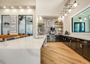 Thumbnail 9 of 32 - A modern kitchen with a white countertop and wooden flooring.
