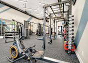 Thumbnail 16 of 32 - A gym with a row of orange dumbbells on the right.