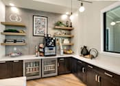 Thumbnail 8 of 32 - A modern kitchen with dark wood cabinets and stainless steel appliances.
