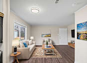 Thumbnail 5 of 10 - A living room with a couch, a coffee table, and a painting on the wall.