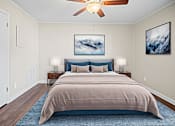 Thumbnail 7 of 10 - A bedroom with a large bed and a ceiling fan.